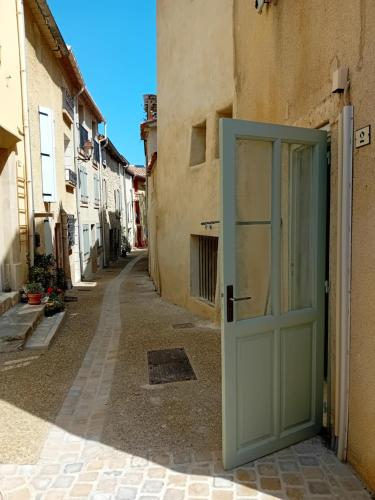 an empty alley with a green door in a building at H2o Chambres d'Hôtes in Peyriac-de-Mer