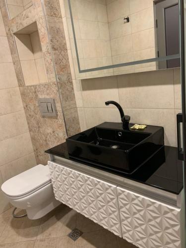 uma casa de banho com um lavatório preto e um WC. em Стандартна стая Пламен em Vratsa