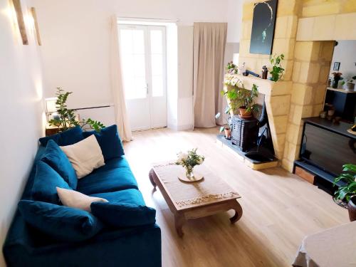un salon avec un canapé bleu et une table basse dans l'établissement Les nids de la tour - Spa privé - wifi, à Saint-Émilion