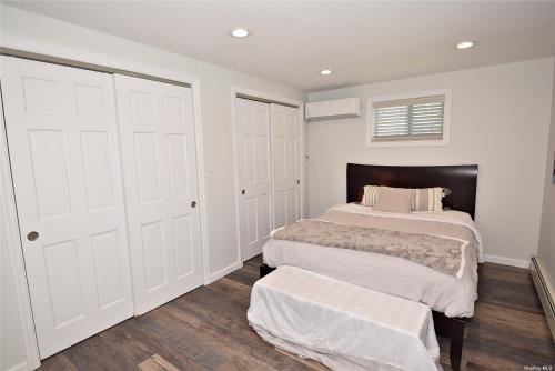 two beds in a bedroom with white walls and wood floors at Romance Vacation Sweet Home 