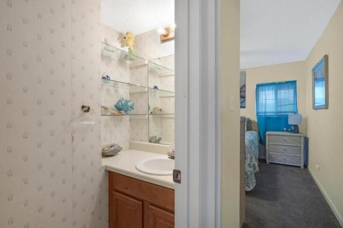 格爾夫海岸的住宿－Summer House West B103，浴室配有盥洗盆和浴缸。