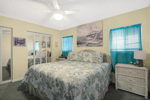 Summer House West B103 في غولف شورز: غرفة نوم بسرير ومروحة سقف