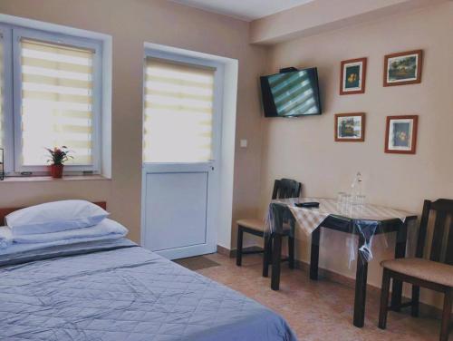 a bedroom with a table and a bed and a table and chairs at Hotel Marislav in Češnovice
