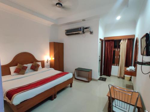 1 dormitorio con 1 cama y TV. en Euro Star Inn en Khajurāho
