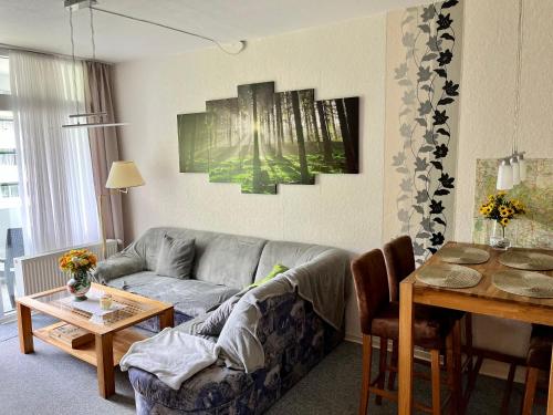 uma sala de estar com um sofá e uma mesa em RuheZeit - inclusive Pool & Sauna em Bad Harzburg