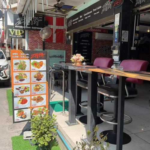 a restaurant with a table and chairs in front of it at Zappa Guesthouse in Pattaya