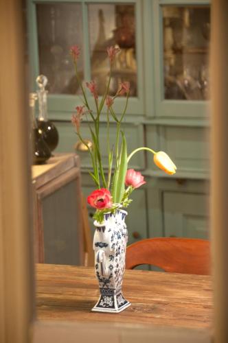 a vase with flowers in it sitting on a table at B&B Herengracht 21 in Amsterdam