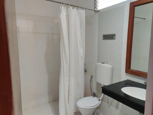 uma casa de banho com um WC, um chuveiro e um lavatório. em Euro Star Inn em Khajuraho