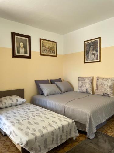 twee bedden naast elkaar in een kamer bij Honey Home in Podgorica