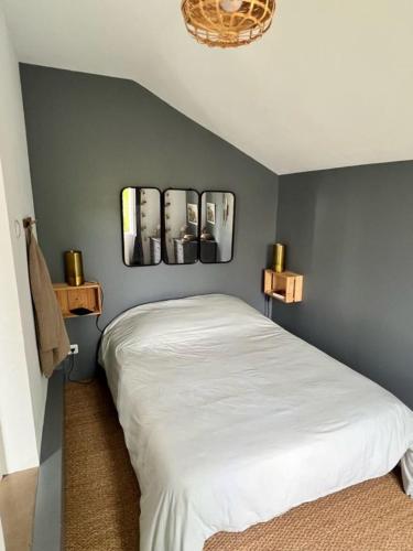 アンデルノ・レ・バンにあるLa maison du Mauretのベッドルーム1室(ベッド1台付)が備わります。壁に3枚の写真が飾られています。