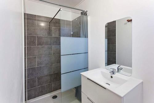 a white bathroom with a sink and a shower at L'escapade créole Jacuzzi Privatif Bungalow Bananier in Saint-Joseph