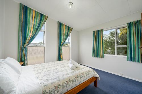 una camera con un letto e due finestre di The Family Hub a Taupo