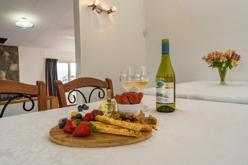 un piatto di frutta e verdura su un tavolo con una bottiglia di vino di The Family Hub a Taupo