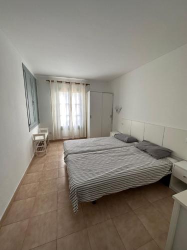 ein Schlafzimmer mit einem großen Bett und einem Fenster in der Unterkunft Apartamentos Calan Blanes Park CB APM 2142 ,nº207 in Cala en Blanes
