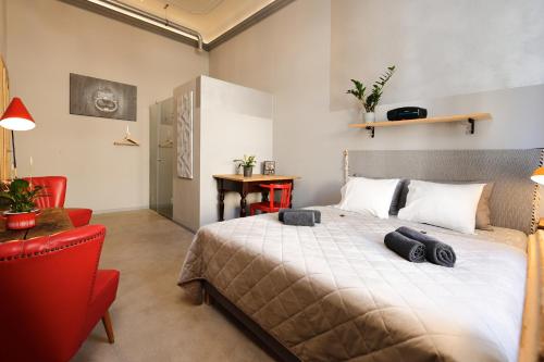 a bedroom with a large bed and a red chair at BudapeStayz - Raday Rooms in Budapest