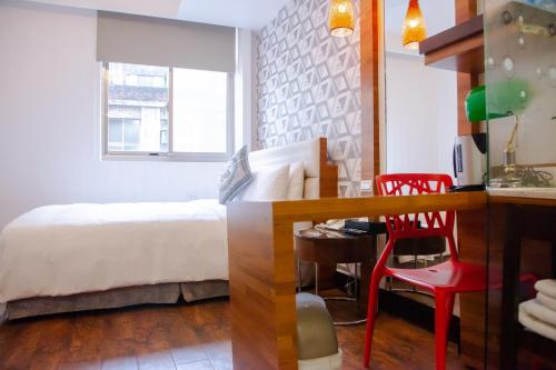 1 dormitorio con cama, escritorio y mesa en E-Coast Star Hotel en Keelung