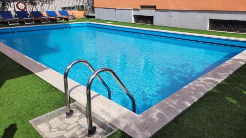 una piscina con corrimano metallico nell'erba di Albergo Villa Mimosa a Torbole
