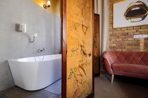 a bathroom with a bath tub in a room at BudapeStayz - Raday Rooms in Budapest