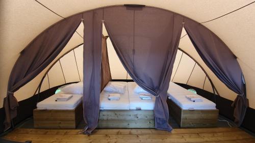 a bedroom with two beds in a tent at Camping Recreatiepark Aalsmeer in Aalsmeer