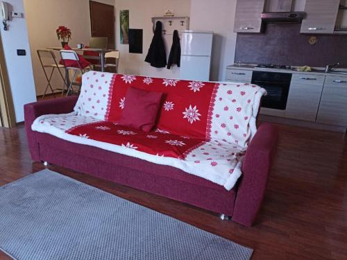 eine lila Couch mit roten Kissen darauf in der Küche in der Unterkunft Trilocale centrale in Seregno