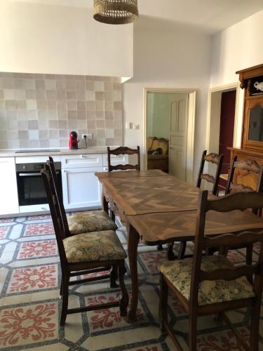 uma sala de jantar com uma mesa de madeira e cadeiras em Manoir de Champvert em Les Vans