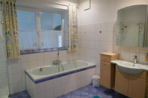ein Badezimmer mit einer Badewanne und einem Waschbecken in der Unterkunft Apartment Neuhauser in Kramsach