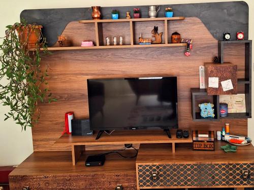 a flat screen tv sitting on top of a wooden entertainment center at My Home in Beysehir