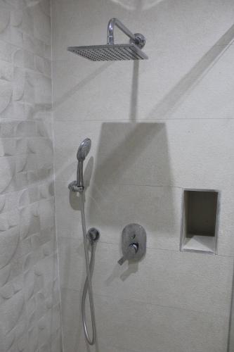 a shower with a shower head in a bathroom at Cosy Apartment in Oualidia City Centre with Free WiFi in Oualidia