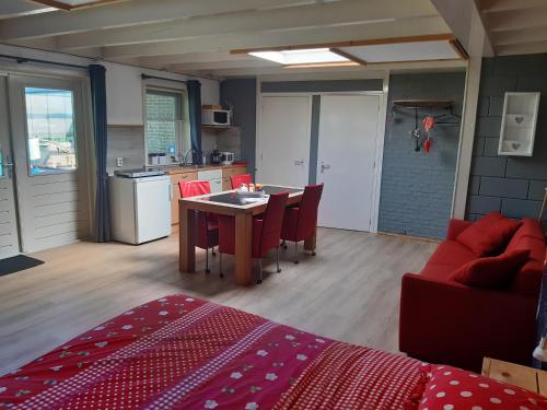 una cucina e un soggiorno con tavolo e sedie di Wetterwillefriesland a Wommels