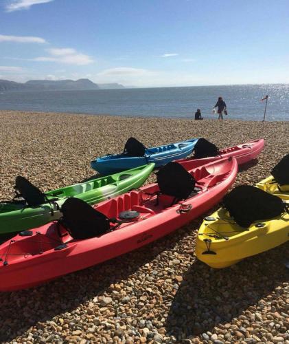a group of kayaks sitting on a rocky beach at Sea Cliff View Designer Home in Lyme Regis