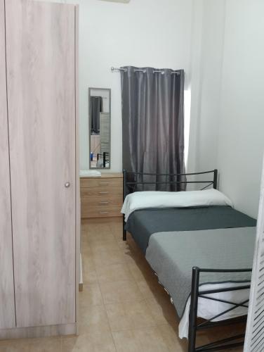 ein Schlafzimmer mit zwei Betten und einem Spiegel in der Unterkunft Studio Jim in Volos