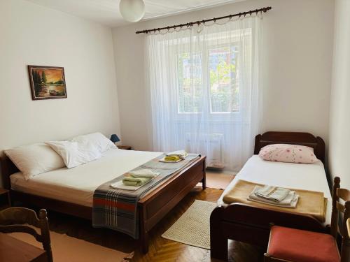sypialnia z 2 łóżkami, stołem i oknem w obiekcie Holiday Home Vesna w Budvie
