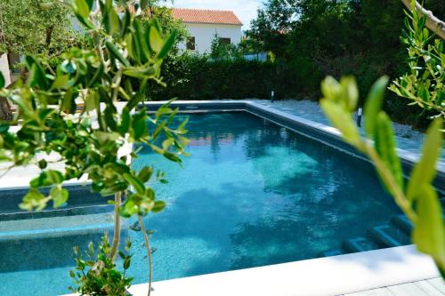 a swimming pool with blue water in a yard at Villa Gem in Mravince
