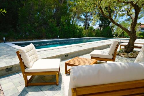 a swimming pool with two lounge chairs and a couch at Villa Gem in Mravince
