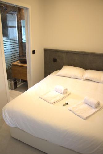 Un dormitorio con una cama blanca con toallas. en 06AO - Superbe appartement avec vue mer exceptionnelle, en Villeneuve-Loubet