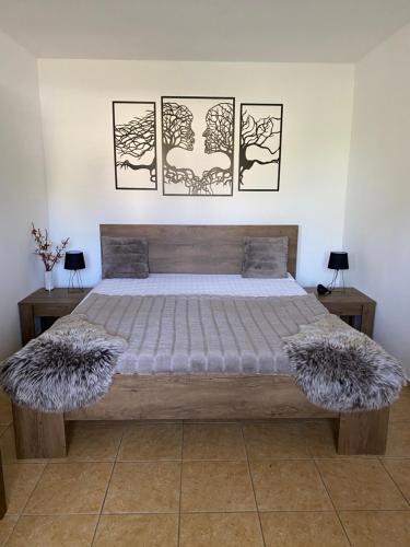 ein Schlafzimmer mit einem Bett mit drei Bildern an der Wand in der Unterkunft Chata Filip in Osečná