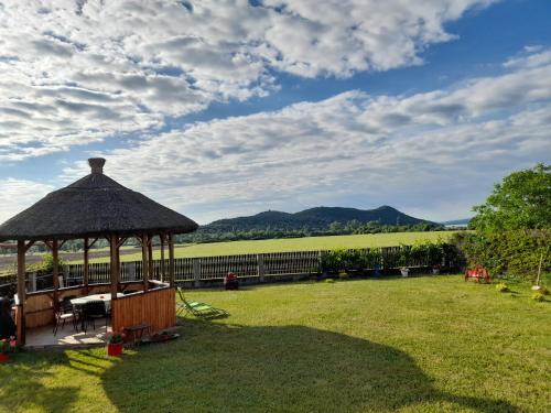 a gazebo in the middle of a grass field at Aszófői Panoráma Apartmanház in Aszófő