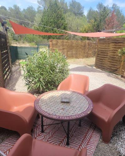 d'une terrasse avec une table, des chaises et une clôture. dans l'établissement Gîtes Casa No-Na, à Flayosc