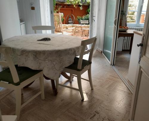 a dining room table with two chairs and a table with a tablecloth at "Les Chacobins" - appart'étape avec Garage Vélos in La Réole