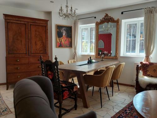 a dining room with a table and chairs and a mirror at Romantisches Ferienhaus in Moselnähe in Maring-Noviand