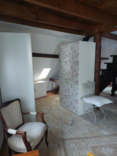a living room with a chair and a table at Romantisches Ferienhaus in Moselnähe in Maring-Noviand