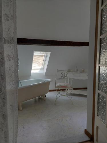 a white bathroom with a tub and a window at Romantisches Ferienhaus in Moselnähe in Maring-Noviand