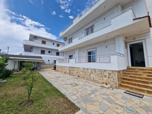 an external view of a house with a stone walkway at Vila Duro in Ksamil
