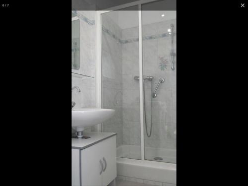 une salle de bain blanche avec une douche et un lavabo dans l'établissement Chez Lulu, à Montreuil