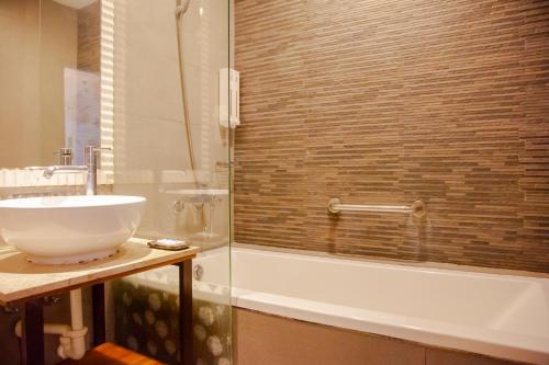 a bathroom with a sink and a bath tub at E-Coast Star Hotel in Keelung