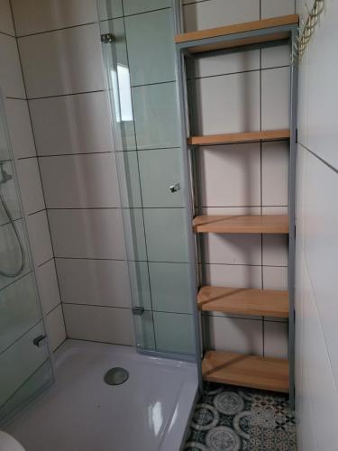 a bathroom with a shower with a glass door at Domek letniskowy Młyn in Karwieńskie Błoto Pierwsze