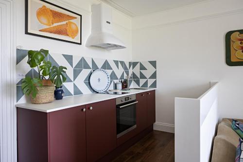 a kitchen with a sink and a stove at Paramount Apartments Ilfracombe, arty seaside holiday apartments in Ilfracombe