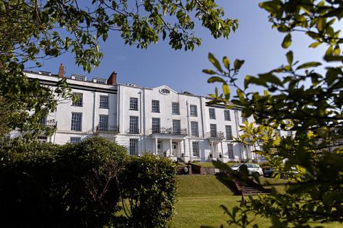 ein großes weißes Gebäude mit vielen Fenstern in der Unterkunft Paramount Apartments Ilfracombe, arty seaside holiday apartments in Ilfracombe