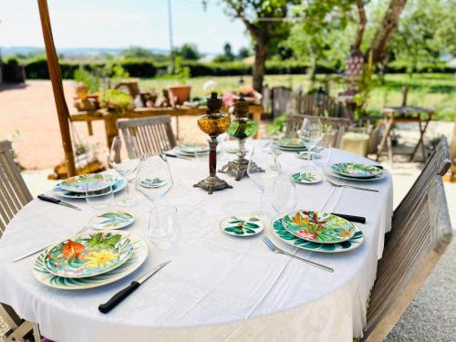 een witte tafel met borden en glazen erop bij Le Presbytere de Leyrat 