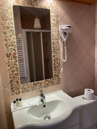 La salle de bains est pourvue d'un lavabo et d'un miroir. dans l'établissement Hôtel La Capitainerie, à Châteauneuf-sur-Loire